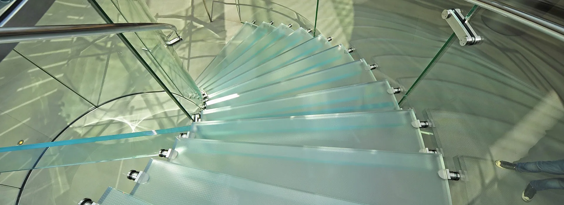 Treppe mit Glasstufen, Glasgeländer und Metallhandlauf
