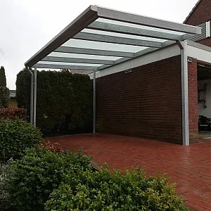 Carport mit Glasdach und Metallgestell an Garage, Seitenansicht