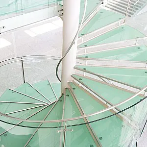 Spindeltreppe mit Stufen aus Glas, Glasgeländer und Metallhandlauf