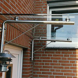 Glasvordach über Haustür mit rechtwinkliger Metallhalterung an Wand