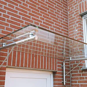 Glasvordach über Haustür mit rechtwinkliger Metallhalterung an Wand, Seitenansicht